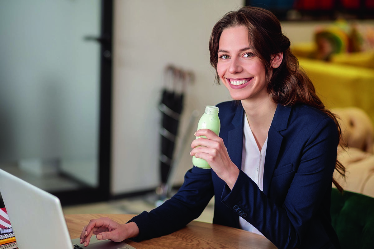 Woman at her desk with meal replacement drink